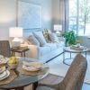 Modern living and dining area with large windows, contemporary furniture, and warm natural light.