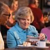 3 Residents having a conversation and opening a gift in a restaurant 